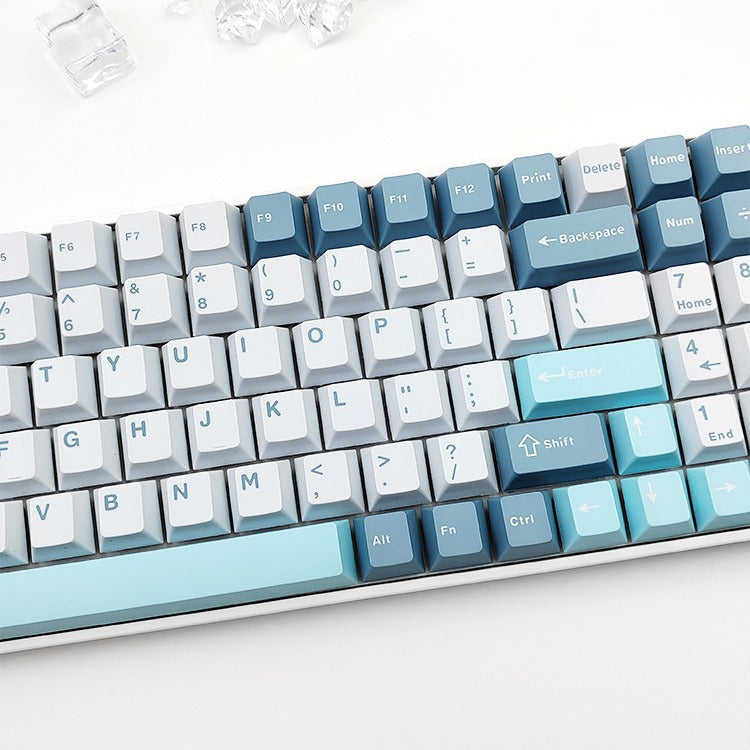 Cloudira – Close-up of two-color keycaps on a keyboard, with blue modifiers, pale grey letters and an aqua spacebar