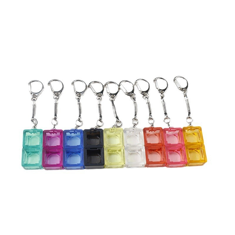Keyloop – Nine 2-slot switch keychains in teal, pink, blue, black, yellow, clear, red, rose and amber, hanging in a row