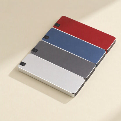 Bytecarry – Four slim metal SSDs in red, blue, gray and silver laid out in a diagonal row on a cream surface