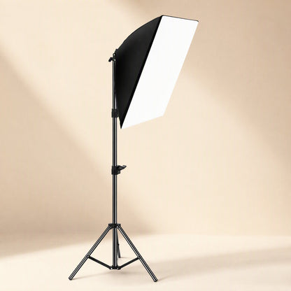 Faceglow – Single softbox light on a black tripod stand, angled down, in a warm beige studio setting
