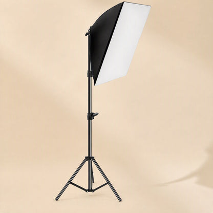 Faceglow – Softbox light on an extended tripod stand viewed from the front, with a beige studio wall behind