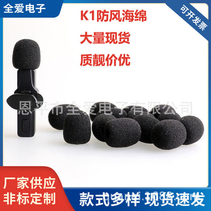 Windsponge Windproof Microphone Cover Sponge: black foam covers in a pile beside a clip-on wireless mic