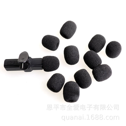 Windsponge – Ten black foam mic covers scattered around a small clip-on microphone on a white background