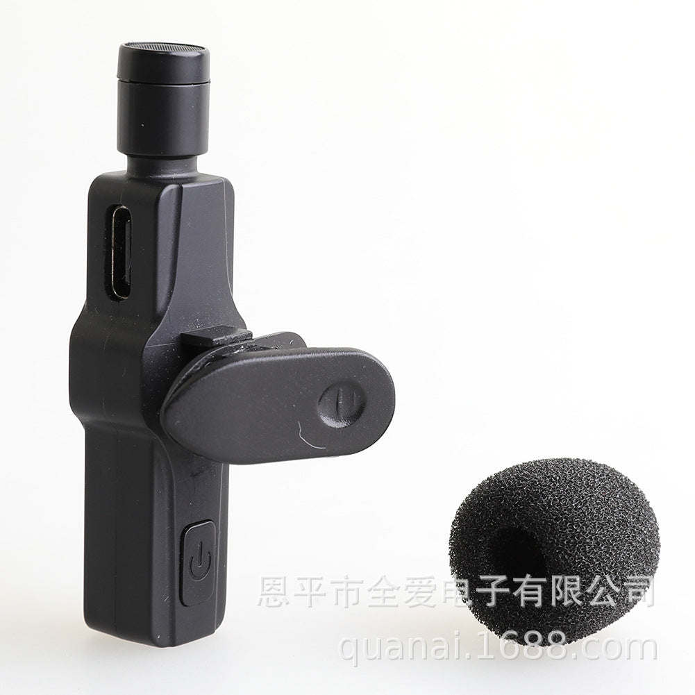Windsponge – Black clip-on microphone with charging port next to a single foam windscreen cover, side view