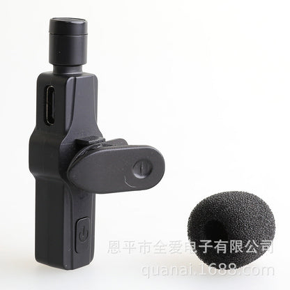 Windsponge – Black clip-on microphone with charging port next to a single foam windscreen cover, side view