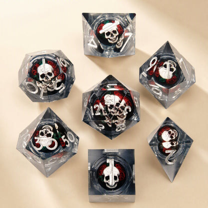 Fateforge – Clear smoky grey resin dice with silver numbers and skulls set in red roses, seven dice on a cream backdrop