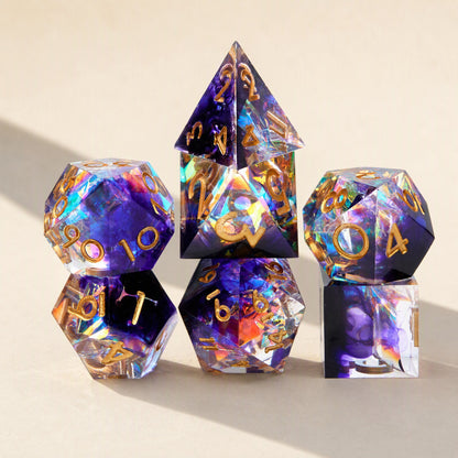Fateforge – Purple and clear resin dice with gold numbers and rainbow prismatic glints, stacked in a standing display