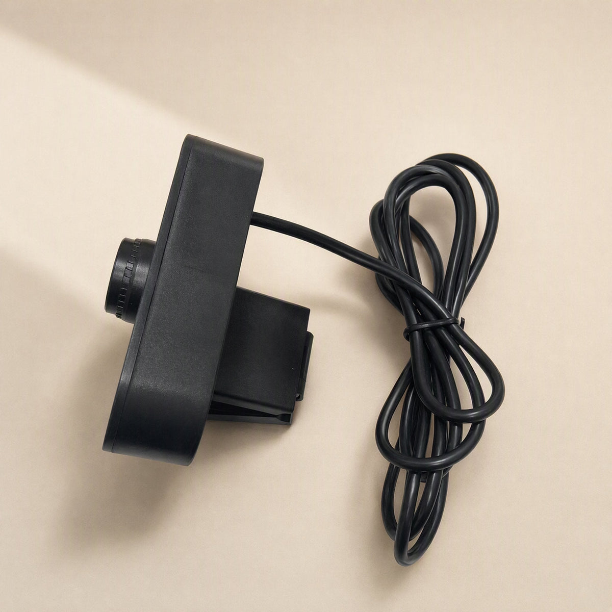 Talkview USB Camera – webcam seen from the side, lying flat with its black USB cable coiled and tied in a loop beside it