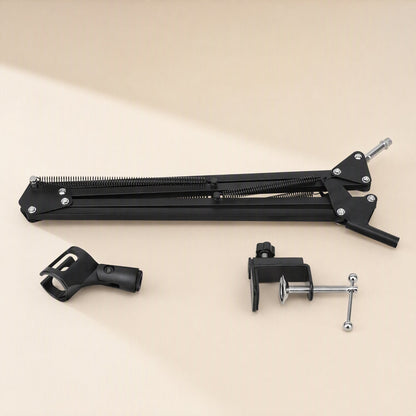 Voicebrace – Disassembled arm folded flat beside the detached microphone clip and desk clamp on a beige surface