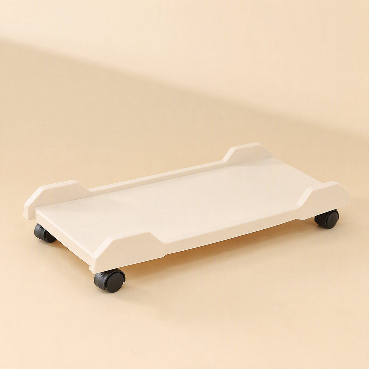 Deskroll – Cream computer stand on wheels from a low side angle, showing its raised corner guards and flat platform