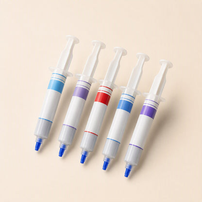 Silkspread CPU Thermal Paste syringes in five colour-banded versions, laid out in a row on a cream background