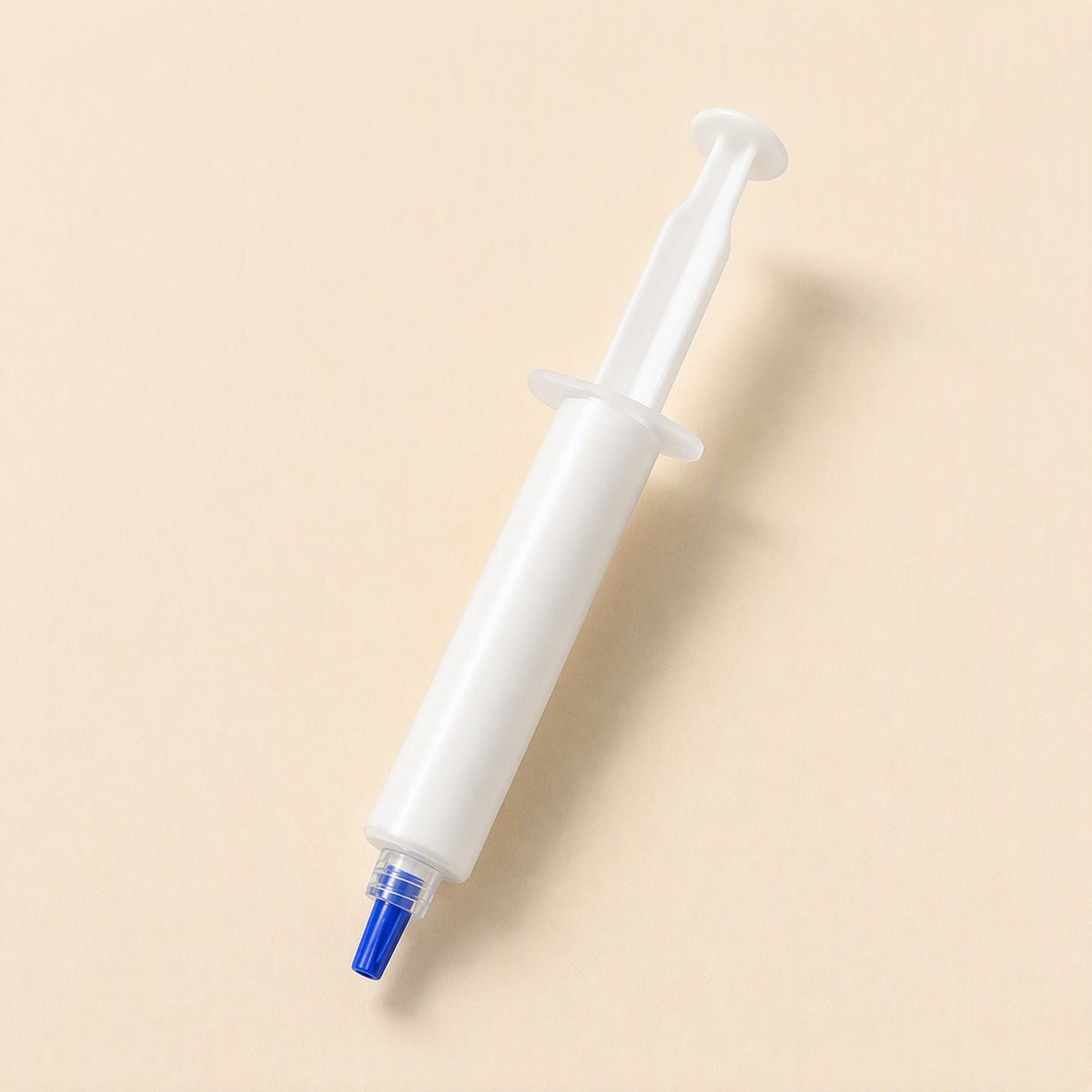 Silkspread CPU Thermal Paste – single plain white silicone grease syringe with a blue tip, angled on a cream background
