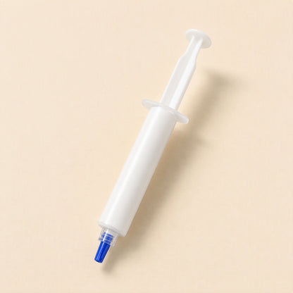 Silkspread CPU Thermal Paste – single plain white silicone grease syringe with a blue tip, angled on a cream background