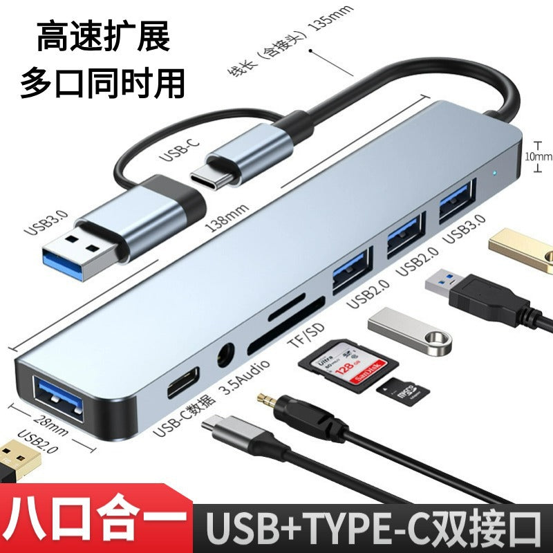 Voltcast Type-C Expansion Dock in gray with dual USB-A and USB-C cable, ports labeled, devices around it