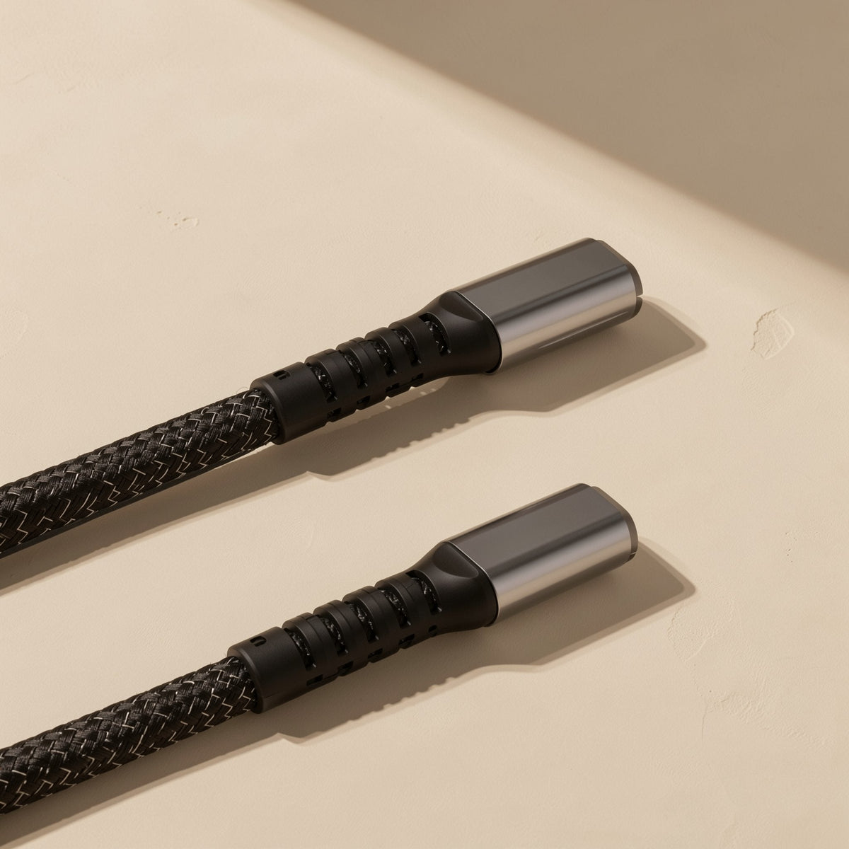 Fastbraid – Close-up of two black braided cable ends with grey metal connector shells and ridged strain relief
