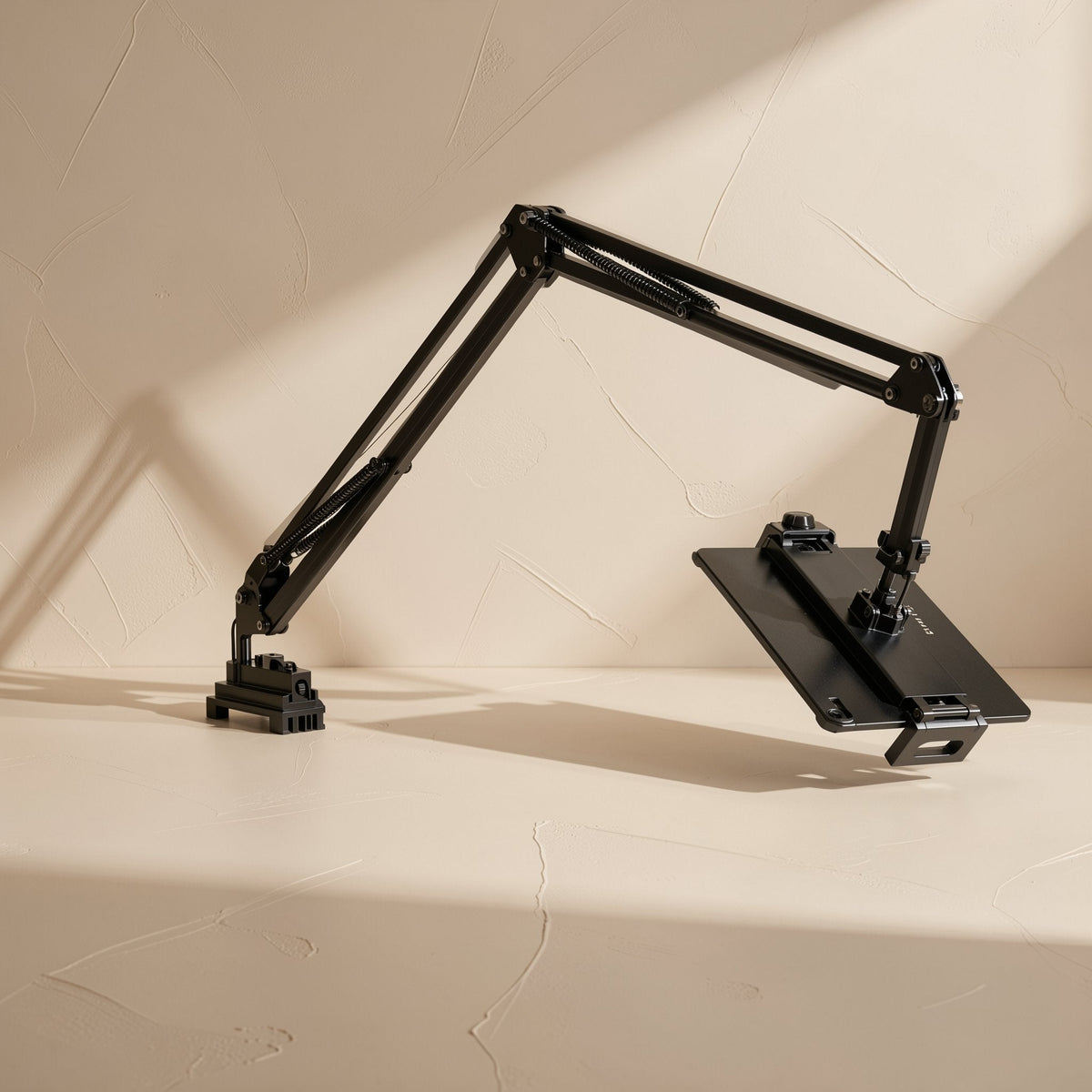 Clampmate Metal Clamp Phone Tablet Holder with black cantilever arm and tablet tray extended over a beige surface