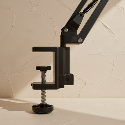 Clampmate – Close-up of the black C-clamp base with threaded screw knob and rubber foot at the arm's lower joint