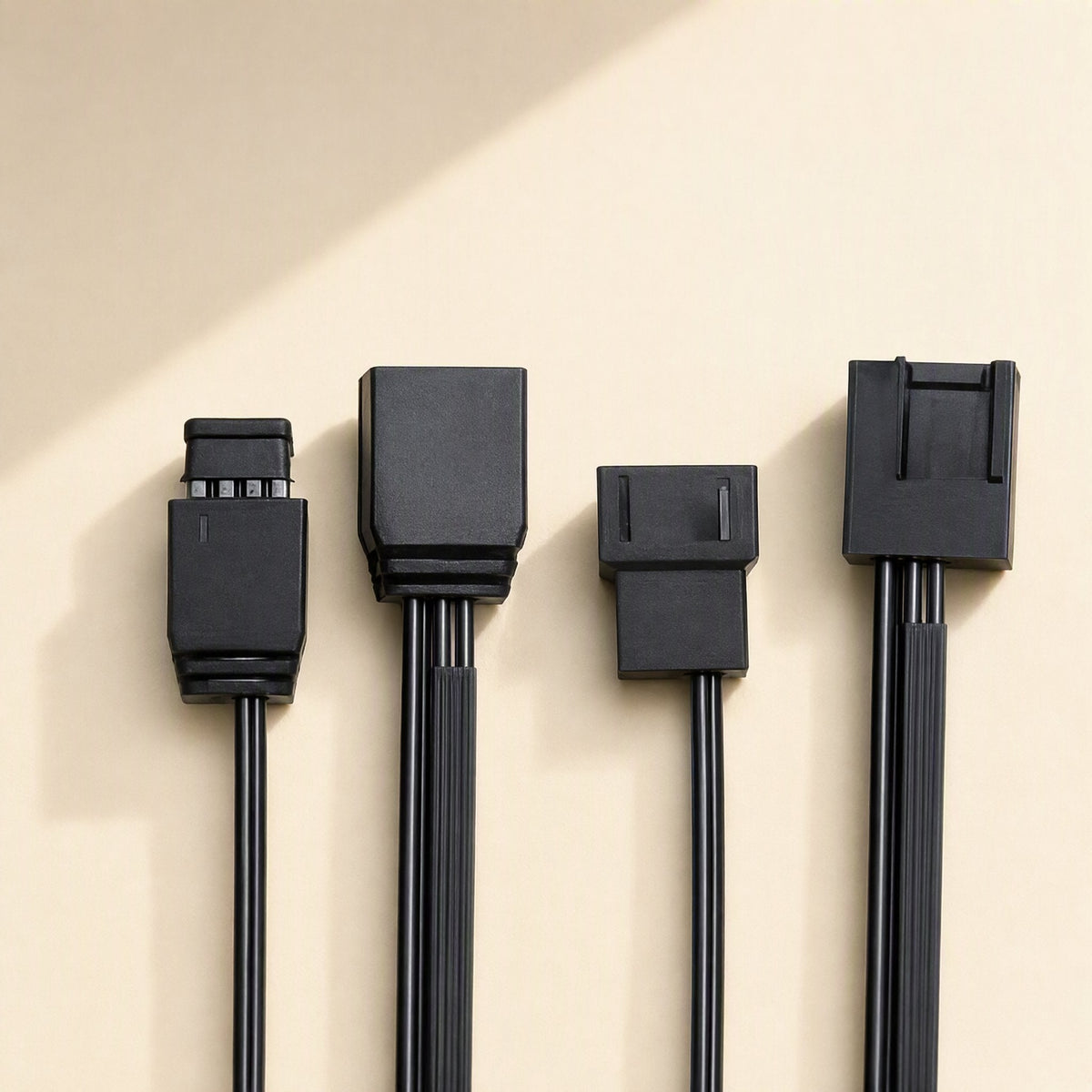 Fanforge Chassis Cooling Fan – four black fan cables with different connector heads lined up against a cream background