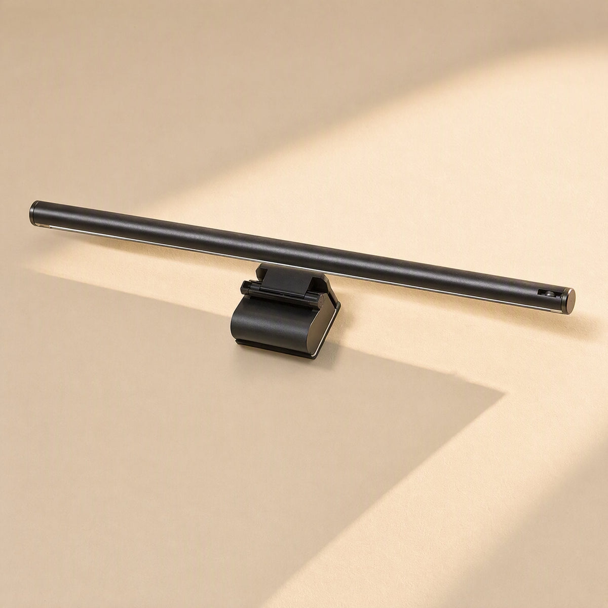 Glowhang – Black light bar with a clip mount resting on a cream surface, seen from the front at an angle