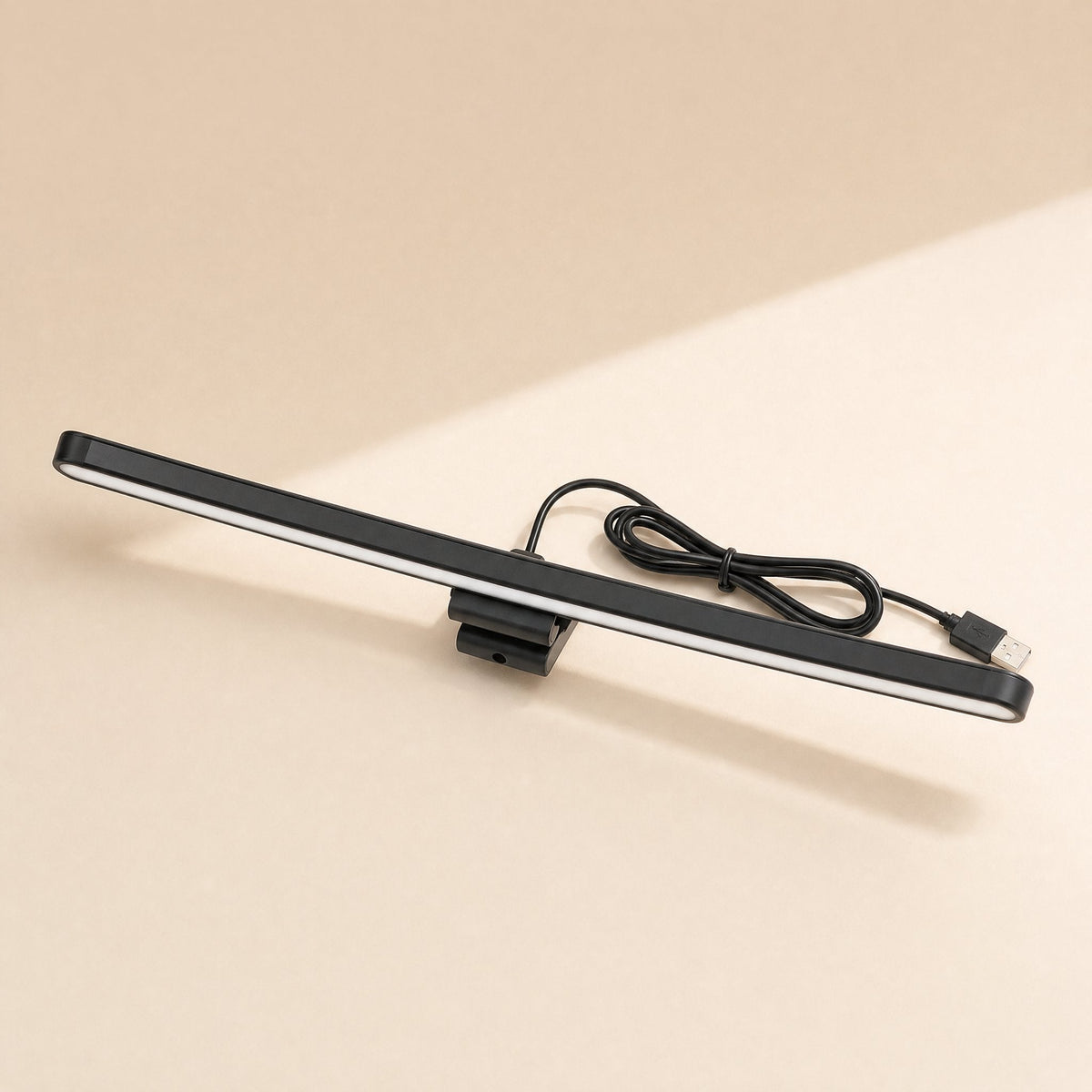 Glowledge – Straight black monitor lamp with a glowing white strip, clip mount and USB cable looped behind