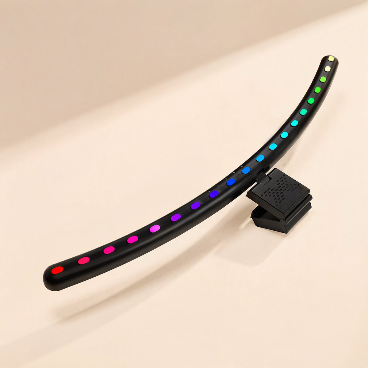Glowledge – Side view of the curved lamp tilted up, rainbow LED dots from red to yellow and a speaker-grille clip
