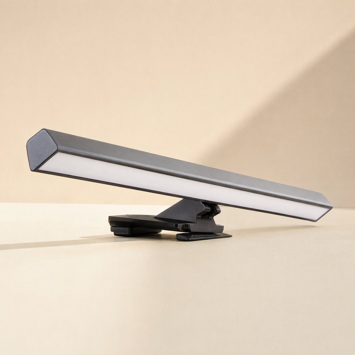 Offsetbeam – Black light bar with clip mount resting on a beige surface, shown from a low side angle