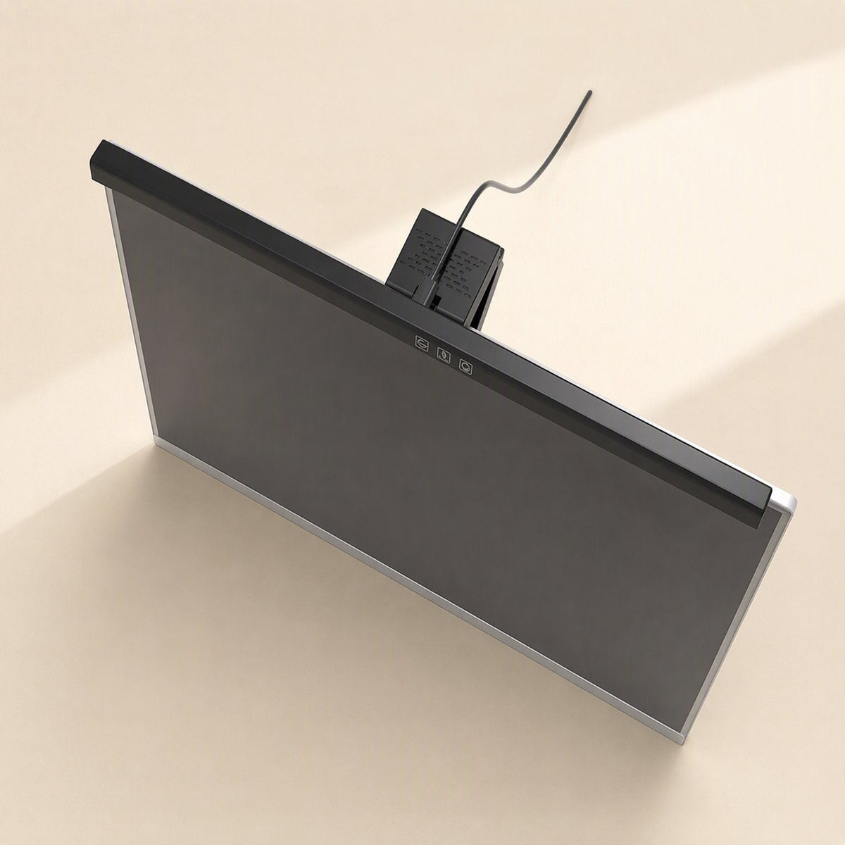 Dimperch – Light bar clipped on top of a monitor, seen from above, with touch controls and a cable at the back