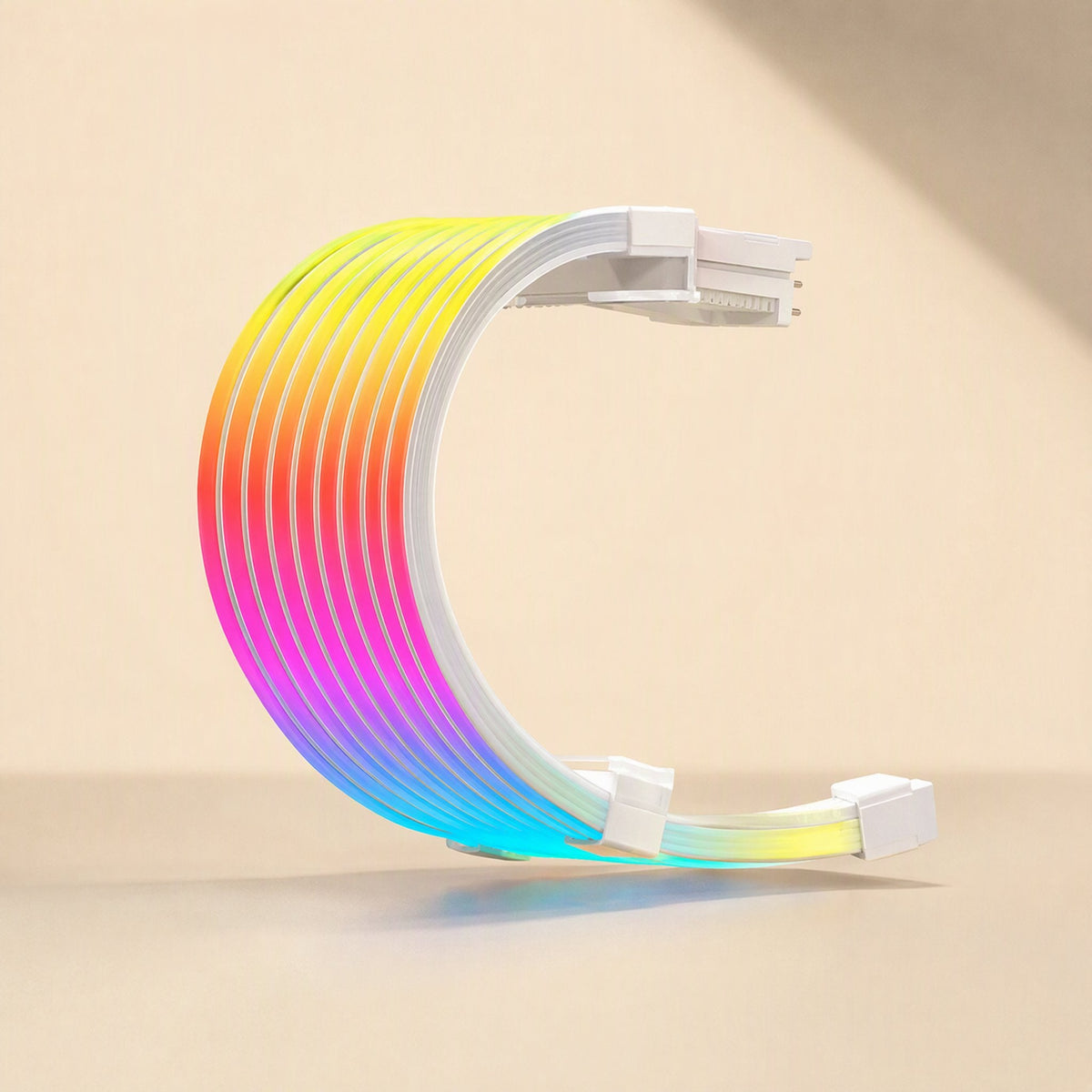 Glowgrid – Curved rainbow neon cable with white connector ends, standing upright on a beige surface