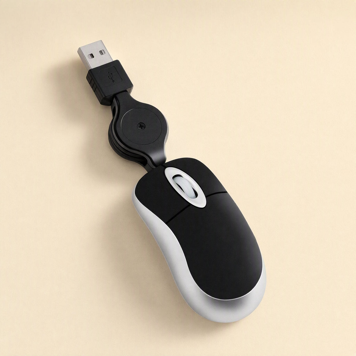 Miniclick Mini Wired USB Mouse in black and white with retractable USB cable, shown from above on beige