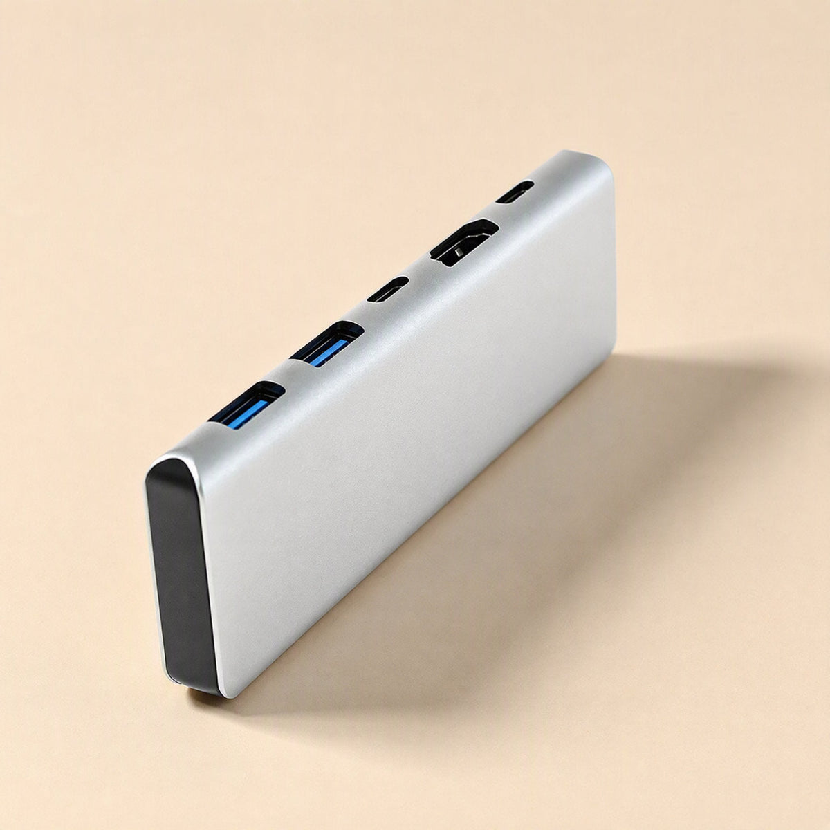 Portpocket – Slim silver docking station standing on its edge, showing two blue USB-A ports, USB-C slot and HDMI port