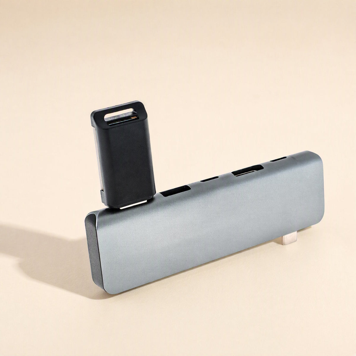 Portpocket – Gray docking station lying flat with a black USB drive plugged into a port at its end, USB-C connector visible
