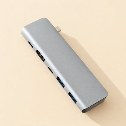 Portpocket – Top-down view of the gray aluminum docking station showing its ports along one edge and USB-C plug at the top