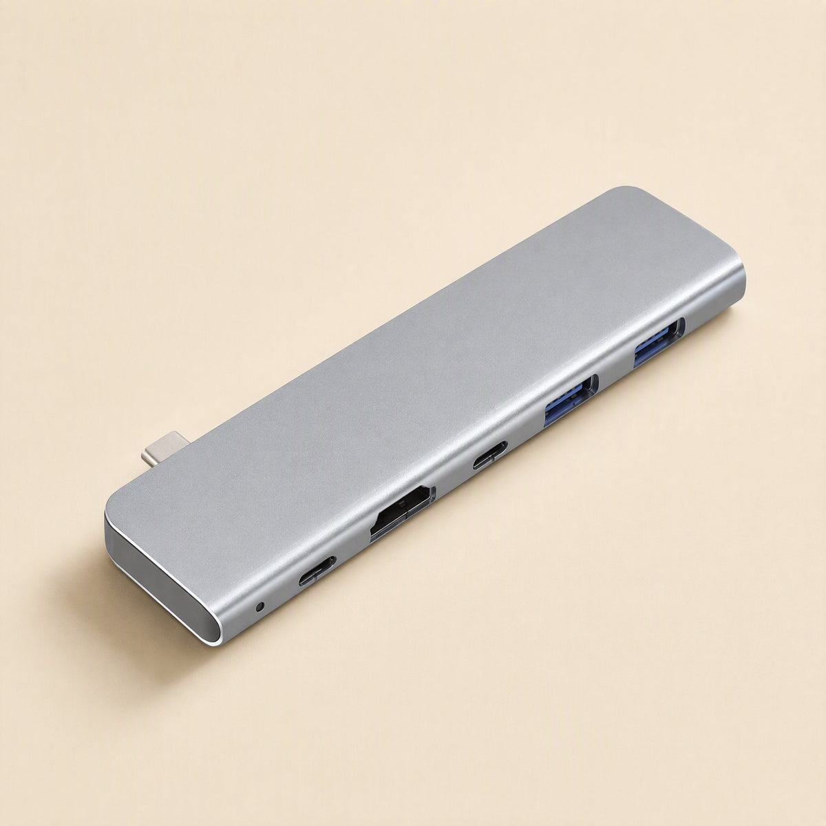 Portpocket – Gray docking station at an angle on a beige background, with USB-C plug, HDMI, USB-C and blue USB-A ports