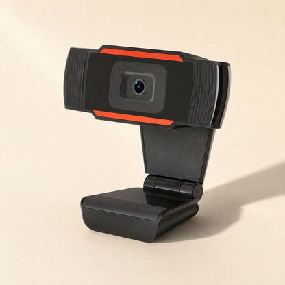 Voicelens – Webcam in three-quarter view showing the angled clip base and hinge, orange trim, soft shadow on the right