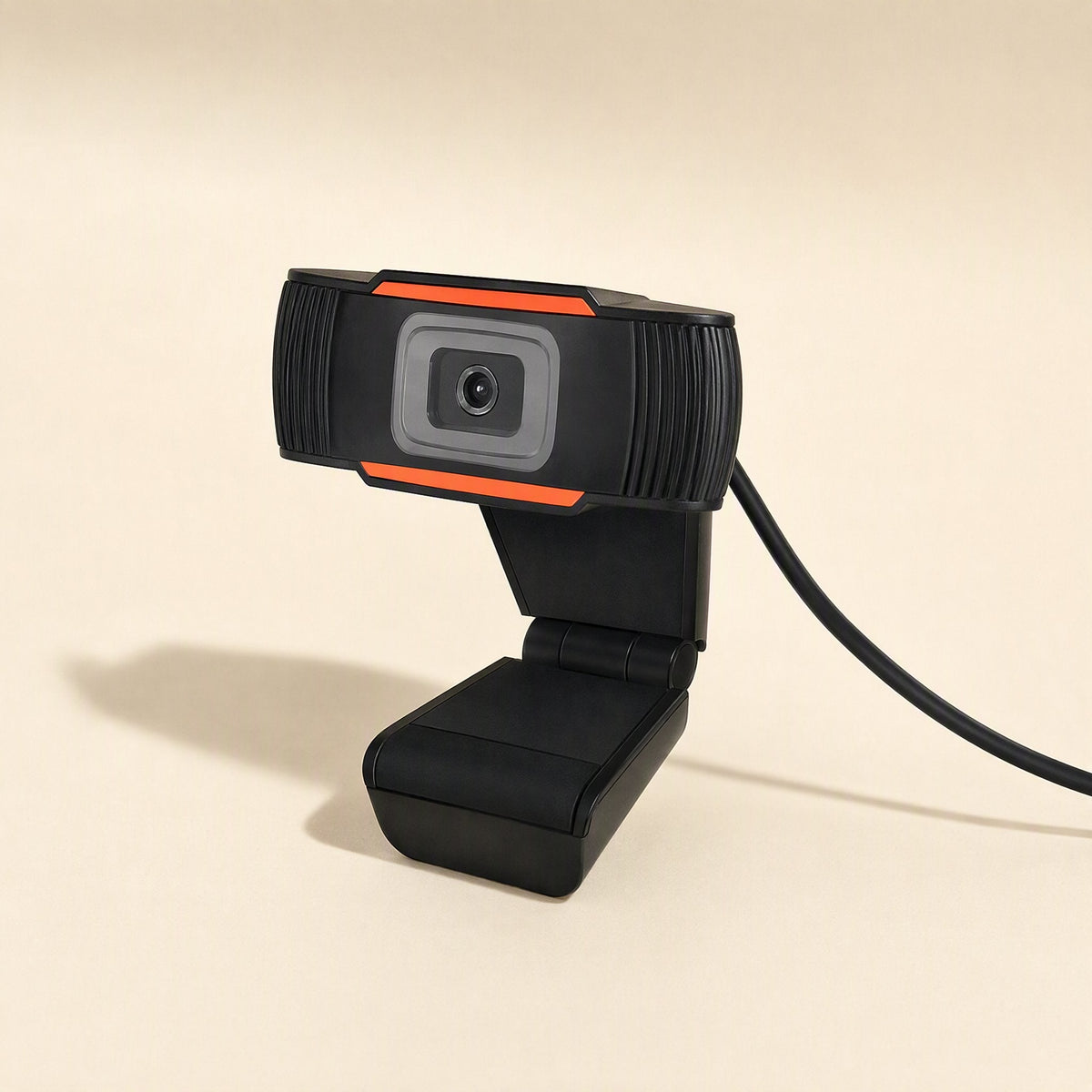 Voicelens – Side angle of the webcam on its folding base, USB cable curving away, shadow cast to the left on beige