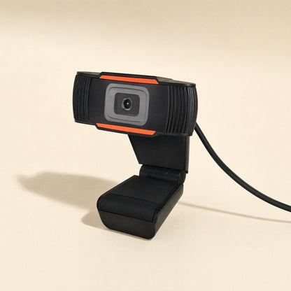 Voicelens – Side angle of the webcam on its folding base, USB cable curving away, shadow cast to the left on beige