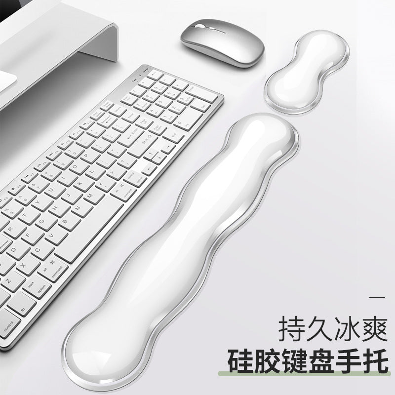 Cushkey silicone keyboard wrist rest and small mouse pad on a desk beside a silver keyboard and white mouse