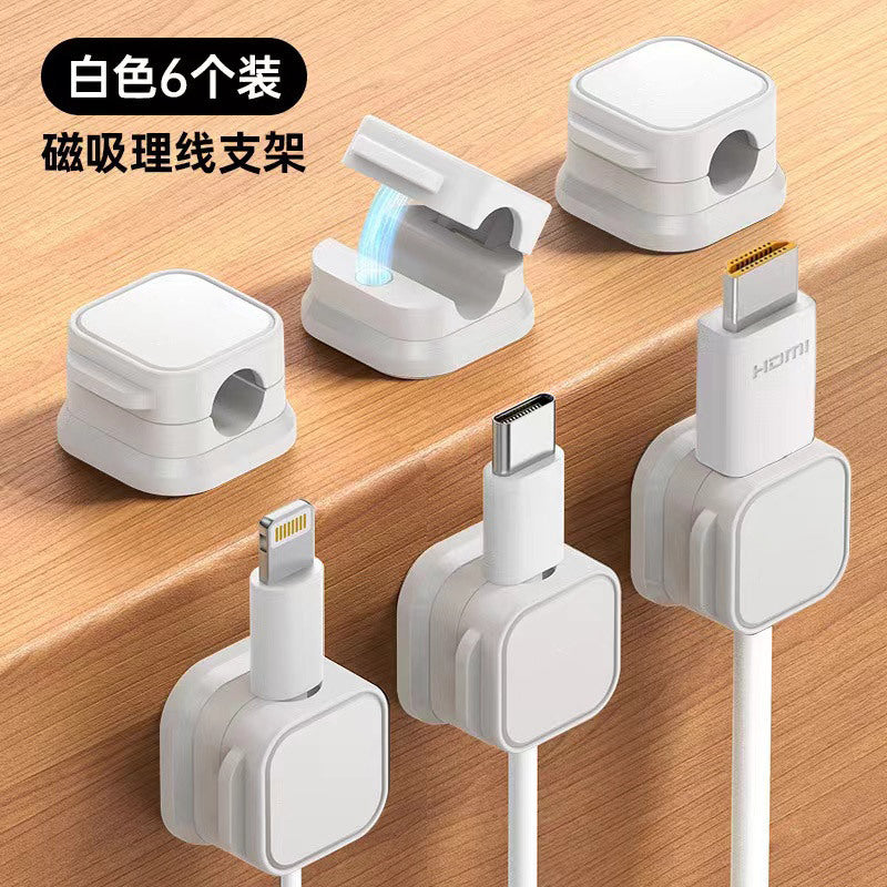 Weftloop Magnetic Adhesive Wire Organizer Clamp, six white clamps, three open and three holding cables on a desk