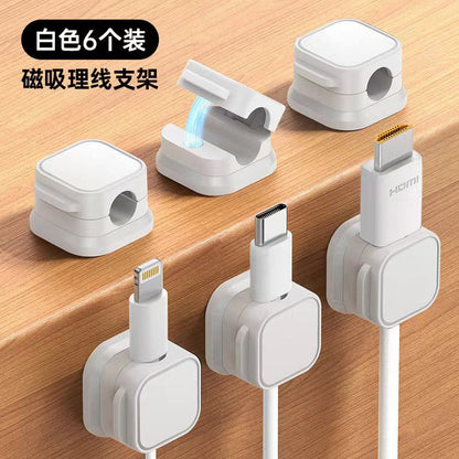 Weftloop Magnetic Adhesive Wire Organizer Clamp, six white clamps, three open and three holding cables on a desk