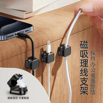 Weftloop – Black cable clamps on a wooden desk edge holding a phone charging cable, Lightning cable and white cord