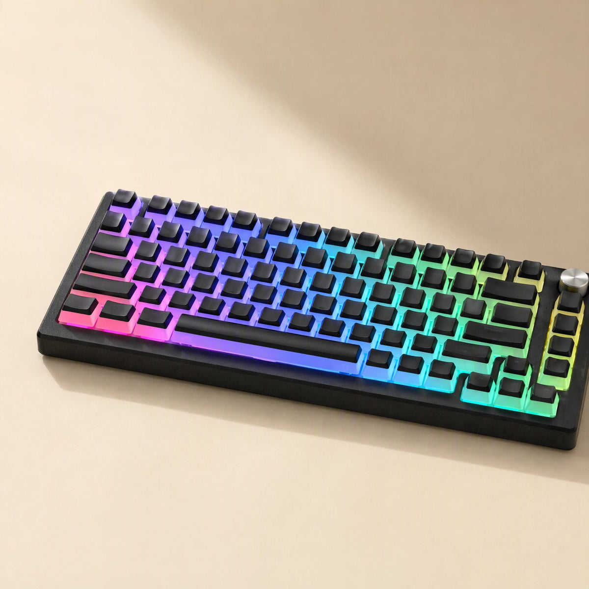 Keyshimmer – Black keycaps on a compact keyboard with rainbow RGB backlight and a metal knob, angled view