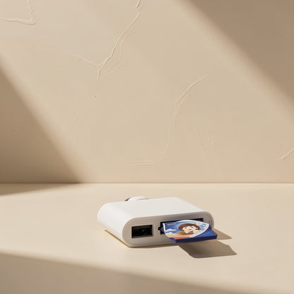 Portbyte – SD card with a cartoon portrait inserted in a white card reader, USB-A port visible on the front