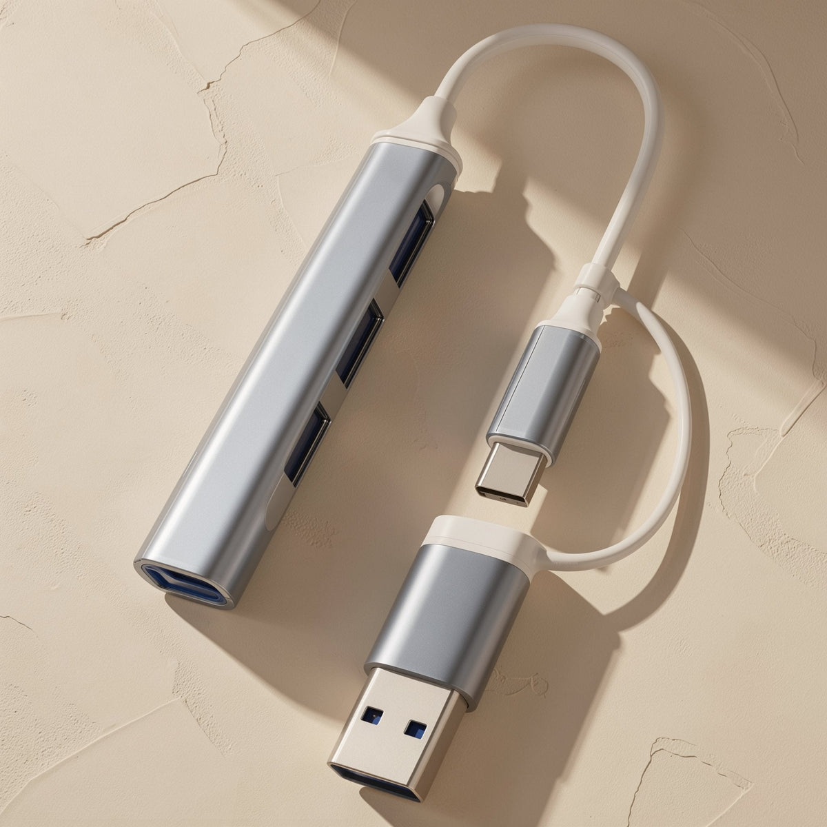 Portstack USB 3.1 Docking Station Hub in silver with USB-C and USB-A plugs on a short white cable, top view