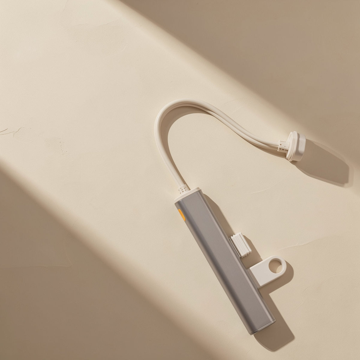 Portstack – Hub lying on a cream surface with a flash drive plugged in and the white cable curving away