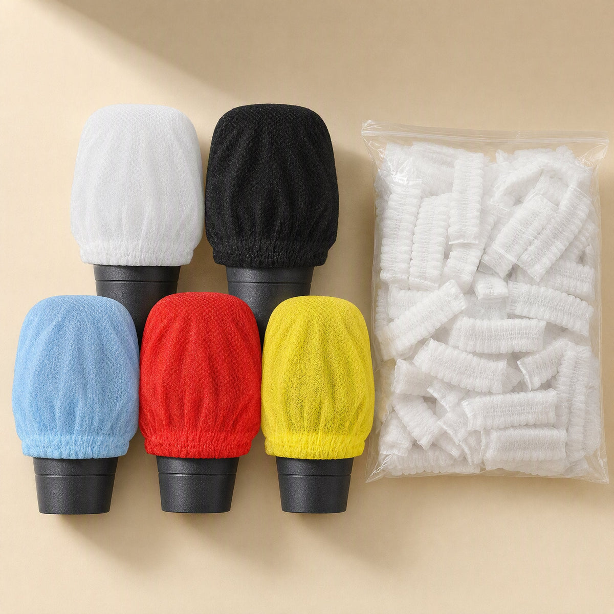 Freshveil Disposable Non-Woven Microphone Cover in white, black, blue, red and yellow beside a clear bag