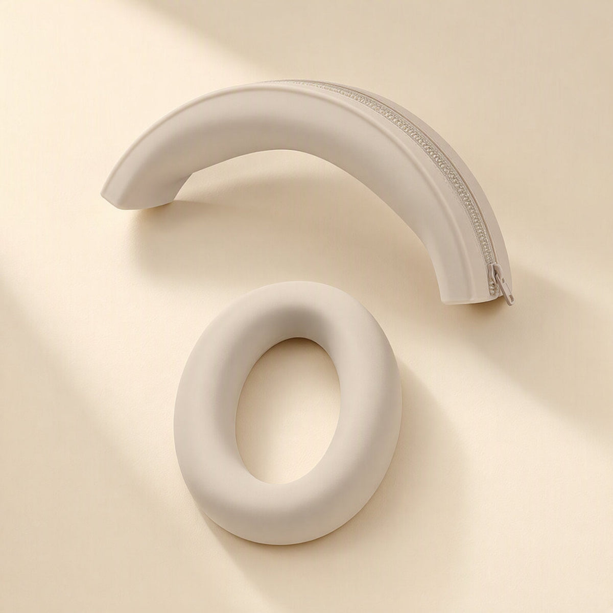 Caseguard – Beige silicone headband cover with zipper beside one beige earcup ring on a cream surface