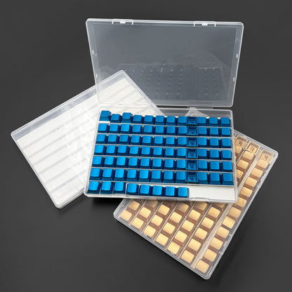 Capview – Open clear trays of blue and gold keycaps with the lid raised and an empty tray with white dividers
