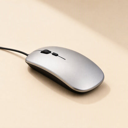 Clickfour USB Wired Mouse in silver with black trim and cable trailing left, on a cream surface