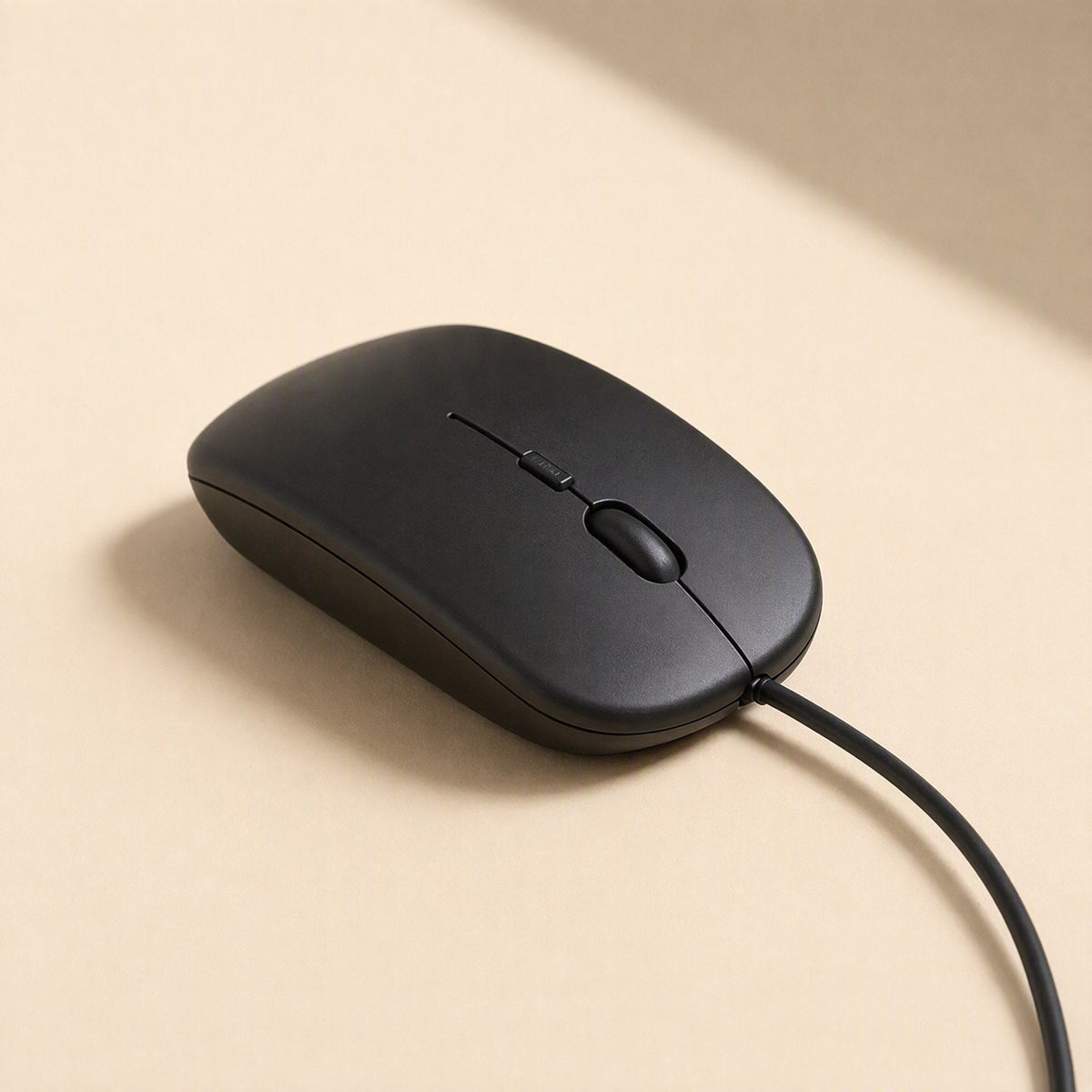 Clickfour – Black matte mouse seen from the front-left, scroll wheel and side button visible, cable curving right