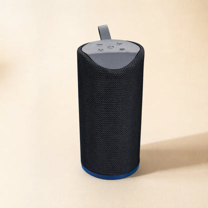 Tuneclip – Black mesh-covered speaker with grey top control panel, strap and blue base ring on a beige background